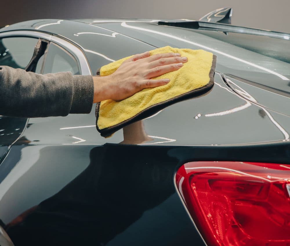 Close-up of a vehicle being polished with a microfibre cloth